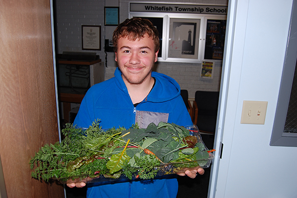 Liam with fresh veggies from the greenhouse
