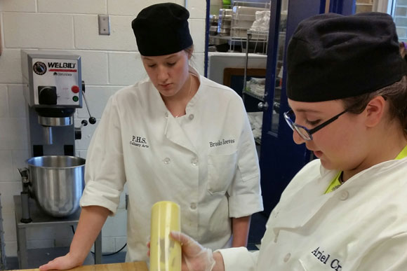 The secret to a truly fulfilling holiday meal? Dessert! Culinary students prepare a cake for the meal�s final touch.