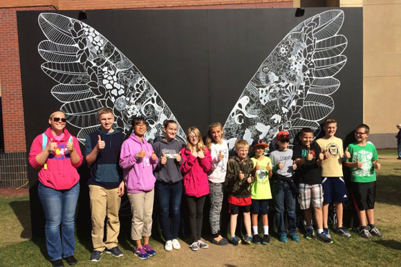 Otsego students strike a pose in front of artwork at Grand Rapids ArtPrize.