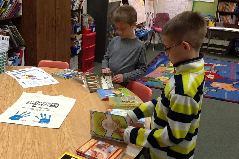 Children select books for the summer on the last day of school.