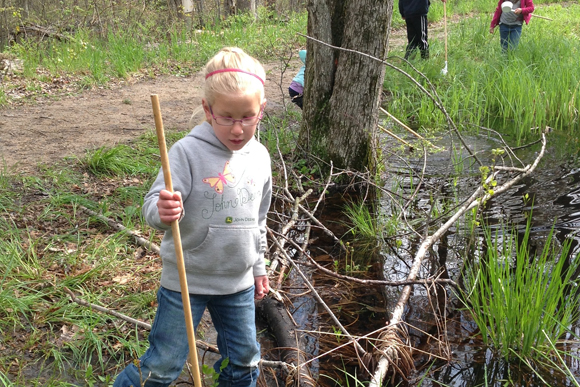 Children spend time outdoors daily, including searching for frogs in spring.