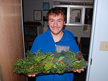 Liam with fresh veggies from the greenhouse