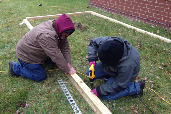 Harper Woods staff members work on building the greenhouse. 