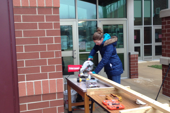 A Harper Woods staff member works on building the greenhouse.