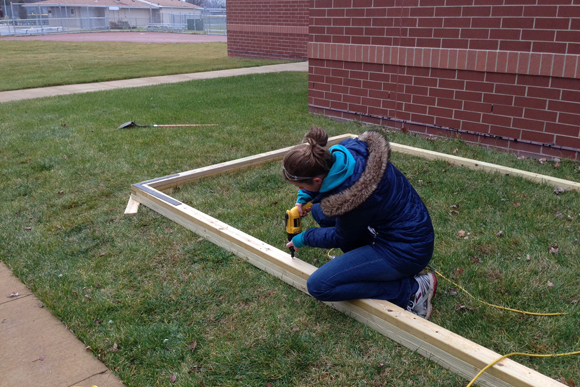 A Harper Woods staff member works on building the greenhouse.