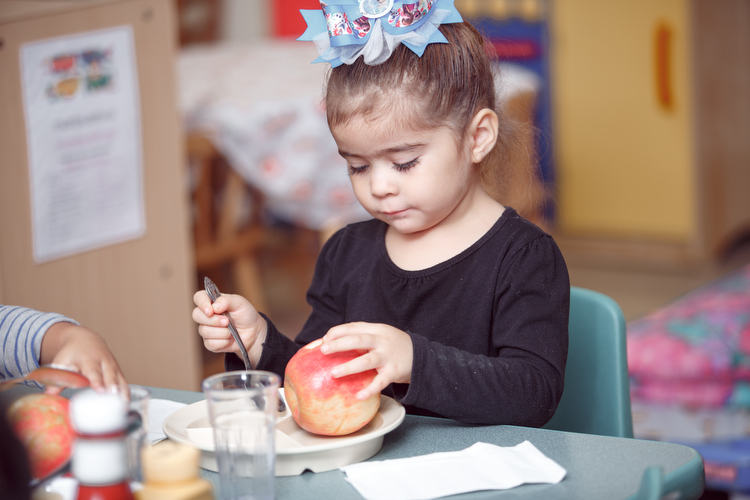 Enjoying a Michigan apple for lunch at the Migrant Head Start program. Photo by Autumn Johnson