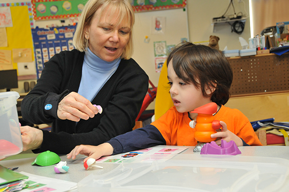 Student and teacher work together building a Mr. Potato Head.