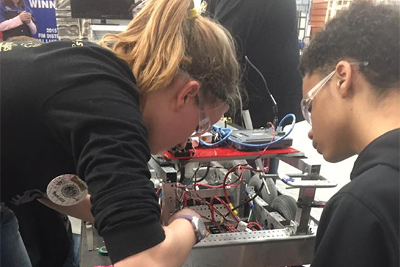 Students Kelsey and Joshua troubleshoot a wiring connection.