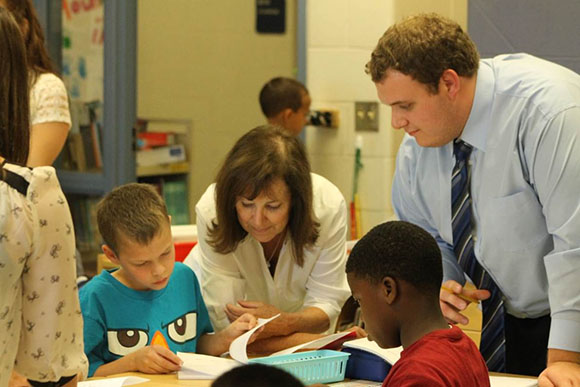 Linda Maniago of the partnership interacts with students and a student teacher.