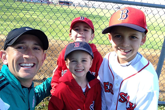 Andrew Chapin poses with his youth baseball players before the first pitch of the game.
